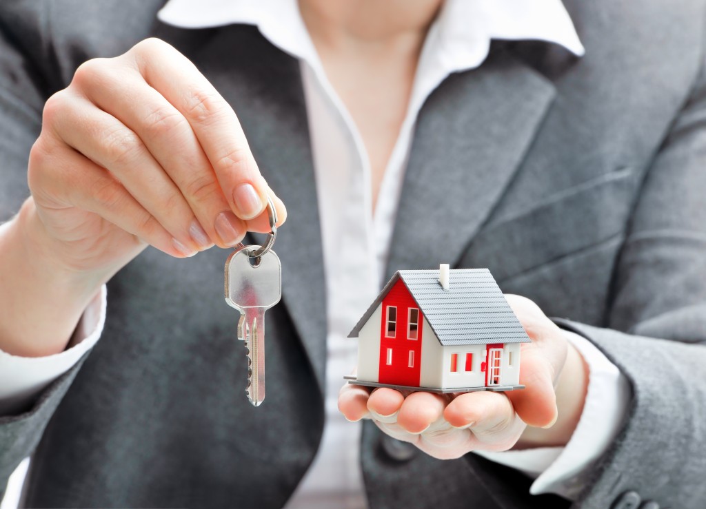 woman holding house model and keys