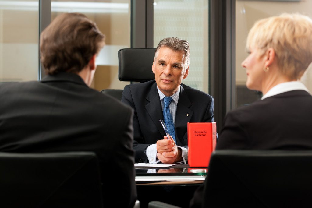 A couple talking to a mature lawyer