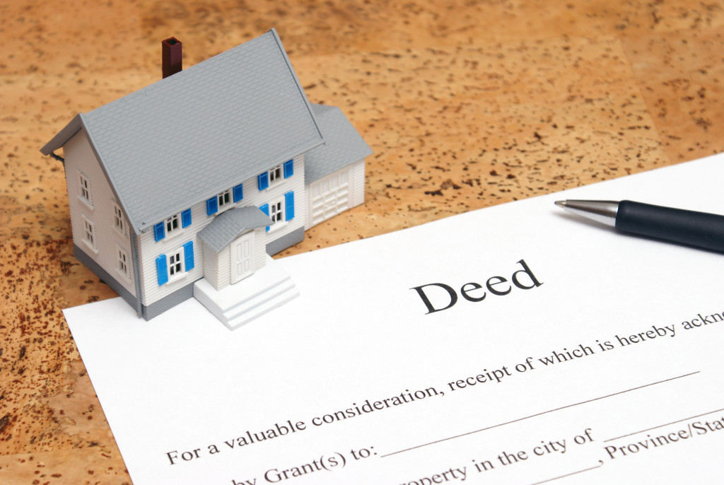 A property deed and a small house model