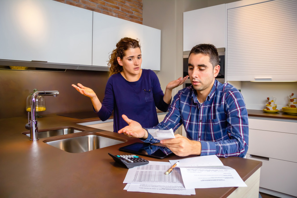 couple facing money problems arguing in the kitchen