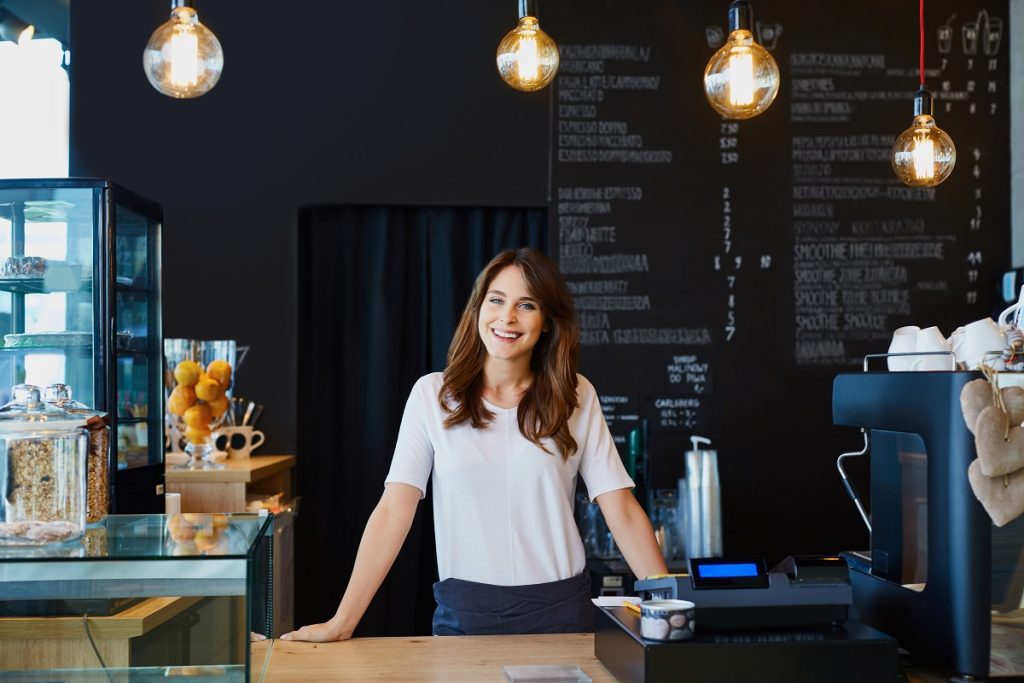 business owner standing at the counter of her coffee shop
