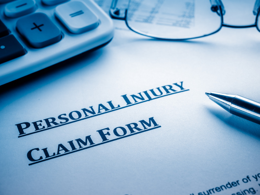 personal injury claim form close up with calculator and glasses